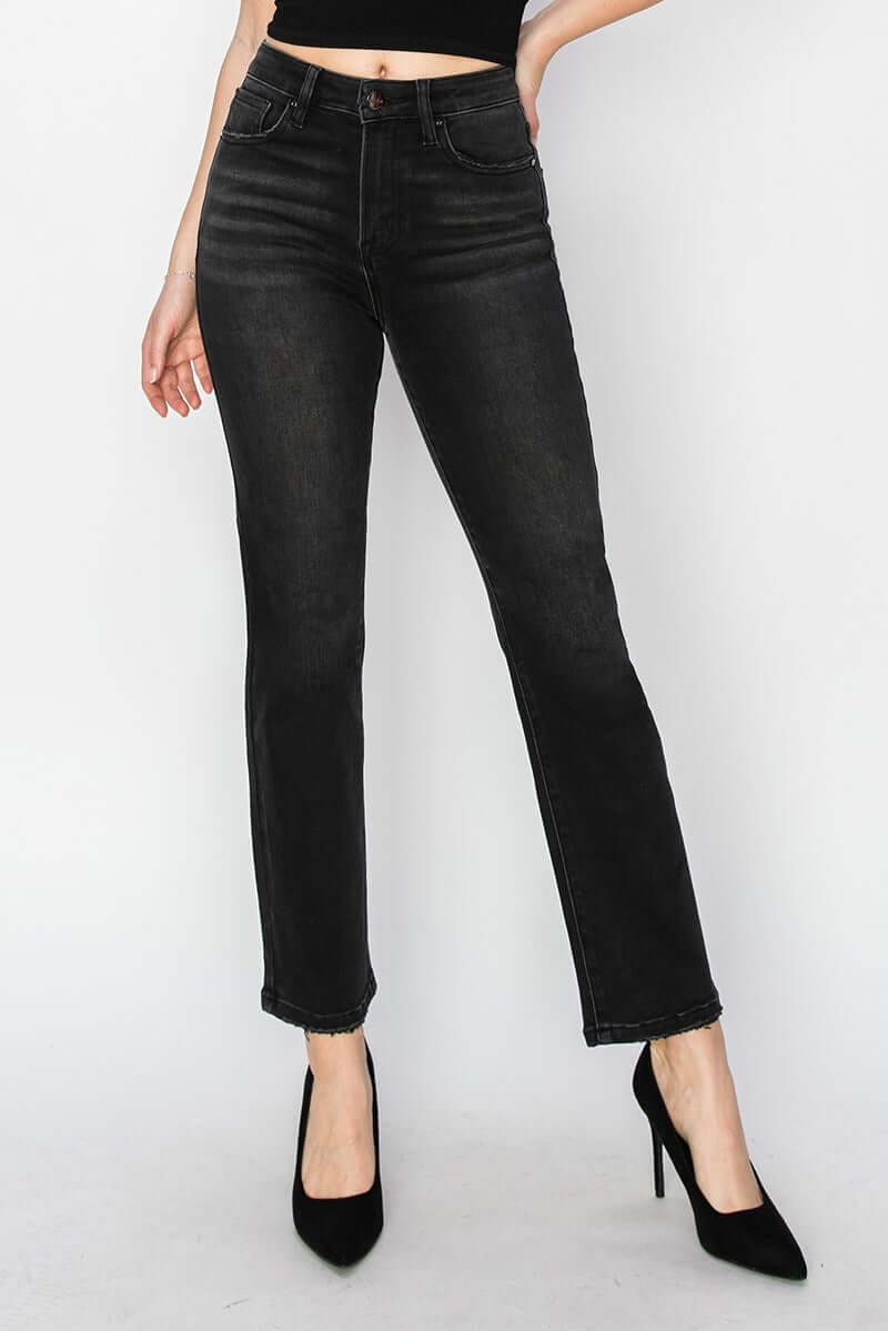 Model showcasing PIPER JEANS by Risen Denim; sleek black straight leg jeans with high waist and stylish heels.