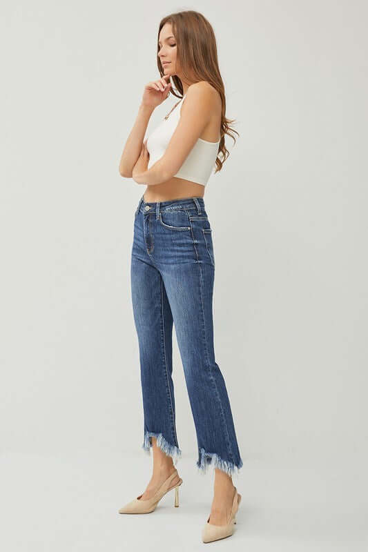 Risen Phoebe Jeans in dark wash with shark bite hem, styled with a fitted crop top and heels.