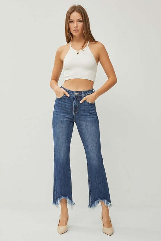 Model wearing Risen Phoebe Jeans in dark wash with chic shark bite hem and a trendy crop top.