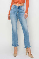 Model wearing RISEN Gracie Jeans, high-rise straight fit with distressed finish and trendy frayed hem.