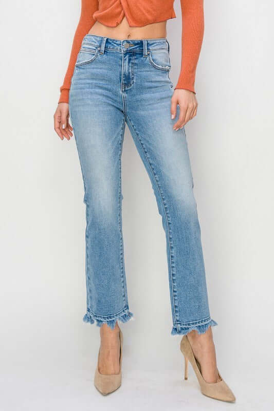Model wearing RISEN Gracie Jeans, high-rise straight fit with distressed finish and trendy frayed hem.