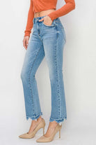Model wearing RISEN Gracie Jeans in light wash with a high-rise, straight fit and distressed hem.