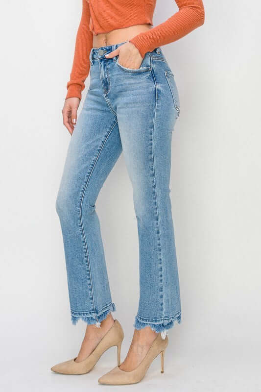 Model wearing RISEN Gracie Jeans in light wash with a high-rise, straight fit and distressed hem.