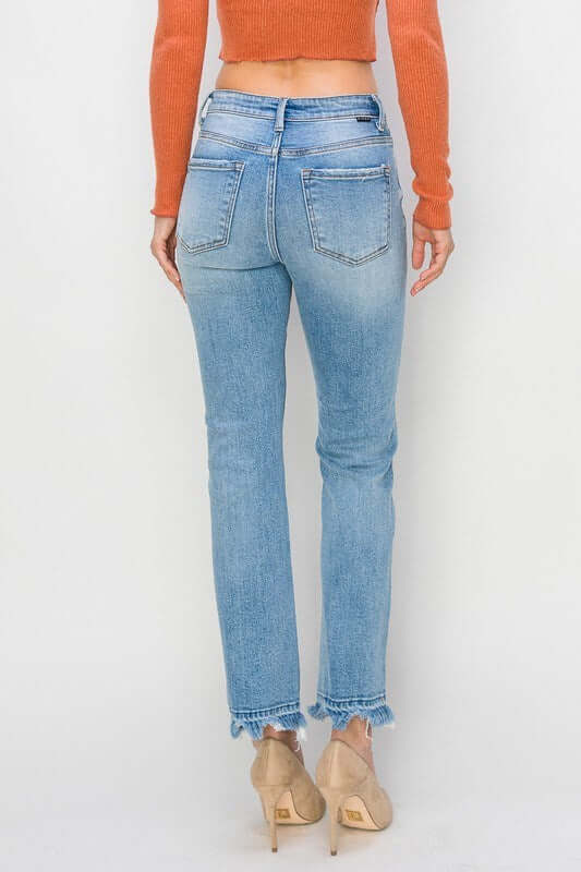 Rear view of woman wearing RISEN Gracie Jeans with a high-rise fit and distressed hem.