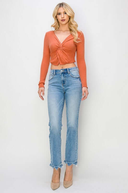Model wearing RISEN Gracie Jeans with a trendy orange top, showcasing high-rise straight fit and distressed design.