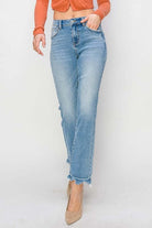 Model wearing RISEN Gracie high-rise straight fit jeans with distressed finish, styled with a trendy top and heels.