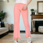 Sierra Sky Jeans in flamingo pink, mid-rise fit, featuring a relaxed thigh and fringed hem for a stylish look.