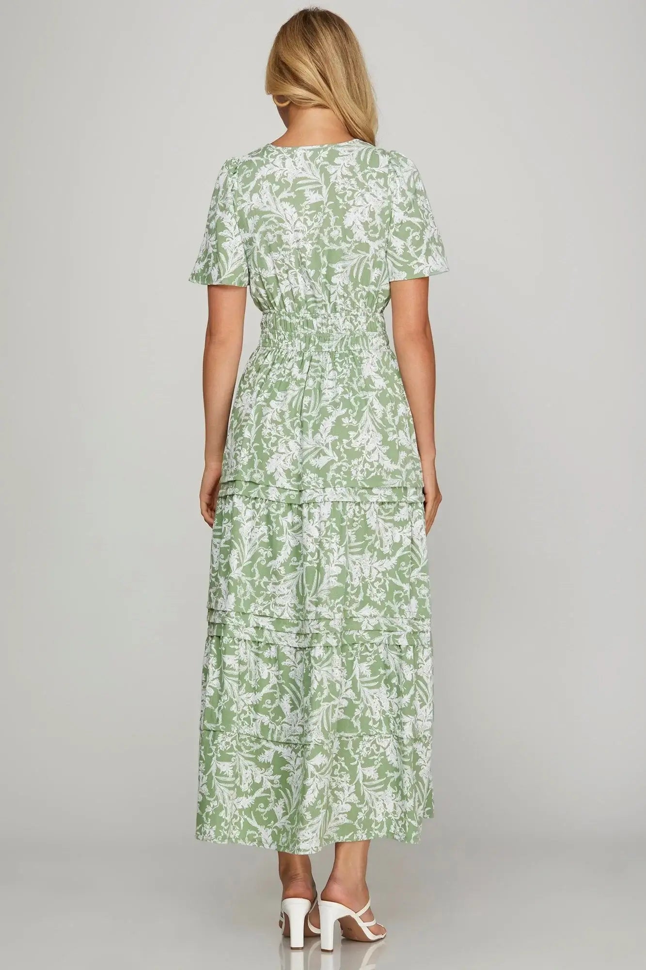 Back view of Meadow Moments dress in sage floral print with tiered skirt and flutter sleeves.