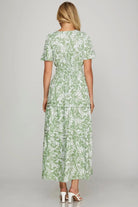 Back view of Meadow Moments dress in sage floral print with tiered skirt and flutter sleeves.