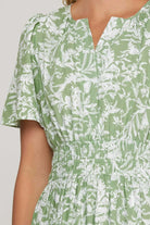 Close-up of the Meadow Moments Dress by She + Sky, featuring a sage floral print and smocked waistband.