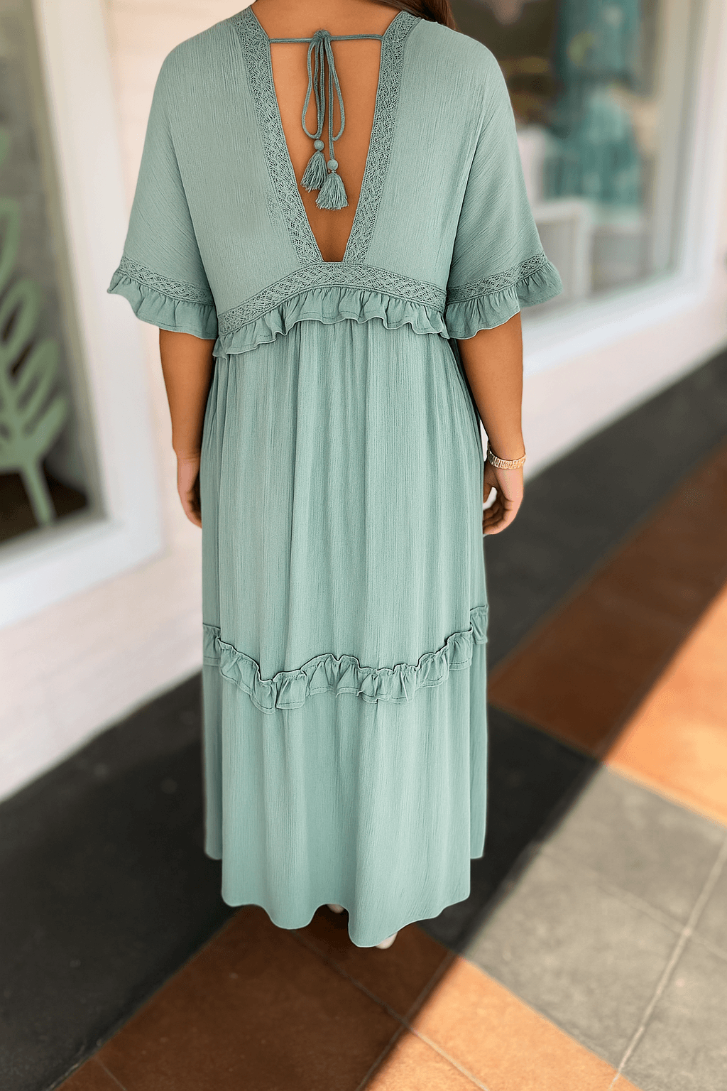 Back view of dusty aqua Ever After Maxi Dress with ruffle layers and tie-back detail, perfect for whimsical occasions.
