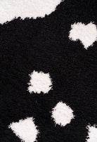 Black and white cow pattern on Cozy Cow Blanket by Howdy Honey, showcasing ultra-soft polyester microfiber texture.