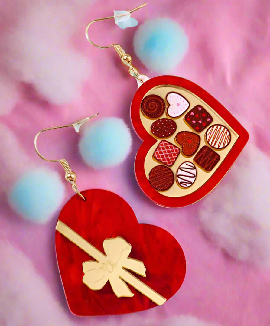 LIFE IS A BOX OF CHOCOLATES EARRINGS adorned with colorful candies and fluffy blue pom poms, perfect for Valentine's Day.