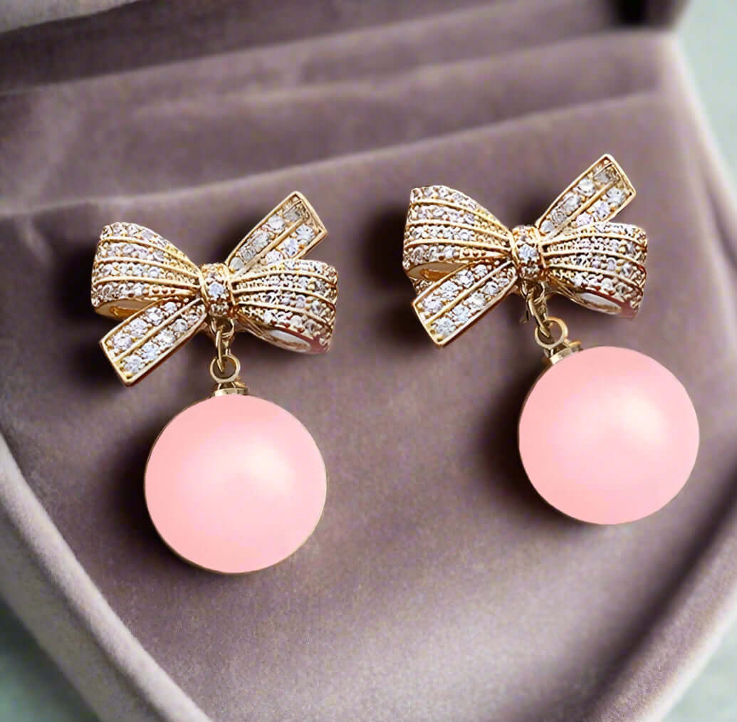 Glamorous Laced Atmo-Sphere Earrings with rhinestone bows and pink dangling spheres.