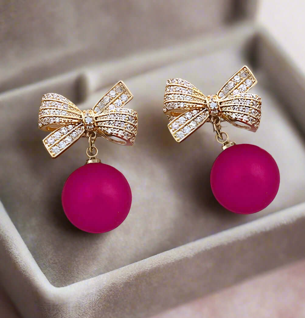 Glamorous LACED ATMO-SPHERE earrings in hot pink with rhinestone bows and dangling spheres.