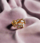 AGAVE LEAF RING with dust white color and gold band on soft fabric surface, showcasing adjustable size and elegance.