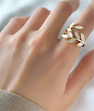 AGAVE LEAF RING featuring adjustable gold tone band and dusty white leaves on a hand.