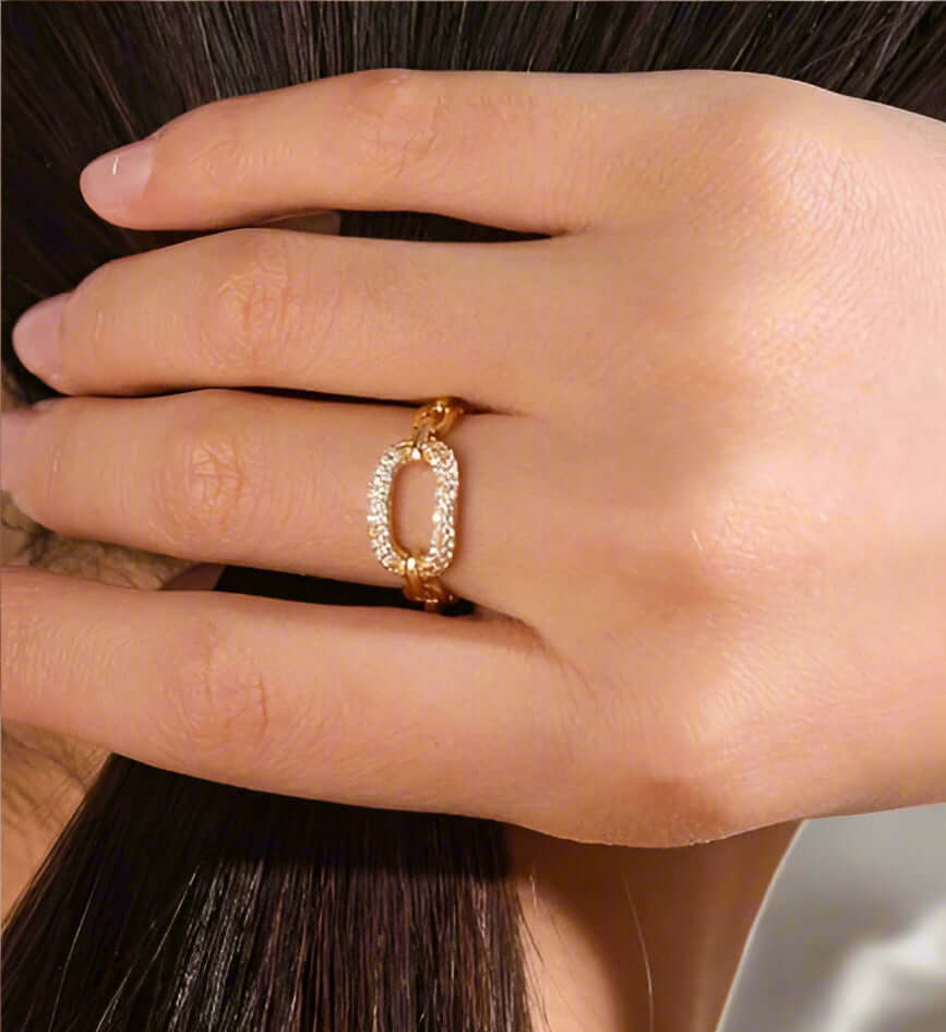 Gold tone Run The Course Ring with rhinestone embellishments worn on a hand, showcasing adjustable size and elegant design.