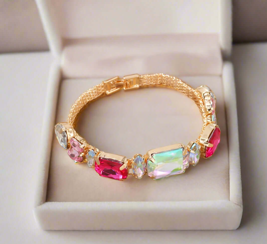 Gold-tone Sparkle Theory Bracelet featuring oversized pink, blue, and iridescent opal gems in a chic design.