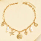 High Tide Treasures Charm Necklace with gold seashells and faux pearls on a gold chain.