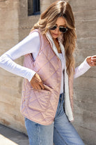 REVERSIBLE RETREAT VEST! Model wearing a pink sherpa lined quilted reversible vest with side pockets.