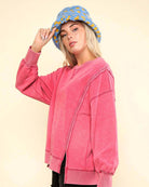 Model wearing FLEX TIME CREWNECK in pink, featuring a relaxed fit and unique stitch details, styled with a blue bucket hat.