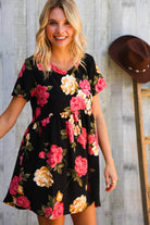 Model wearing the Twilight Garden Party Dress featuring vibrant floral patterns on a black background.