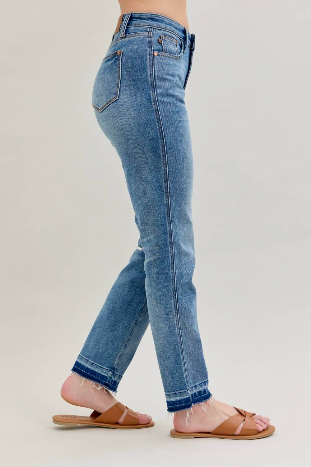 Model showcasing JUDY BLUE - AVERY JEANS with a mid-rise fit and modern release hem detail.