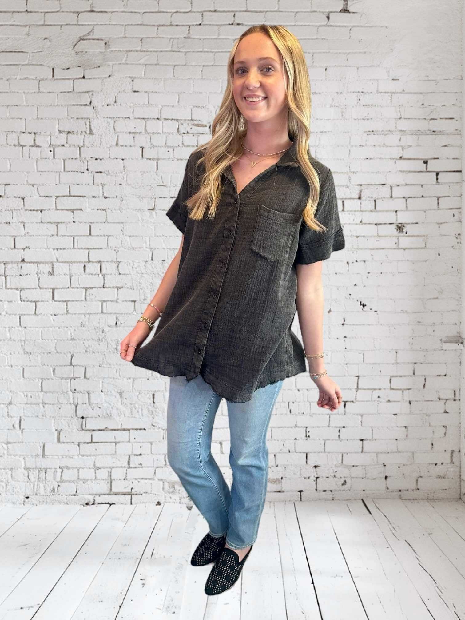 Model wearing the Midnight Mist top by Umgee, featuring a V neckline and frayed hem, styled with jeans.