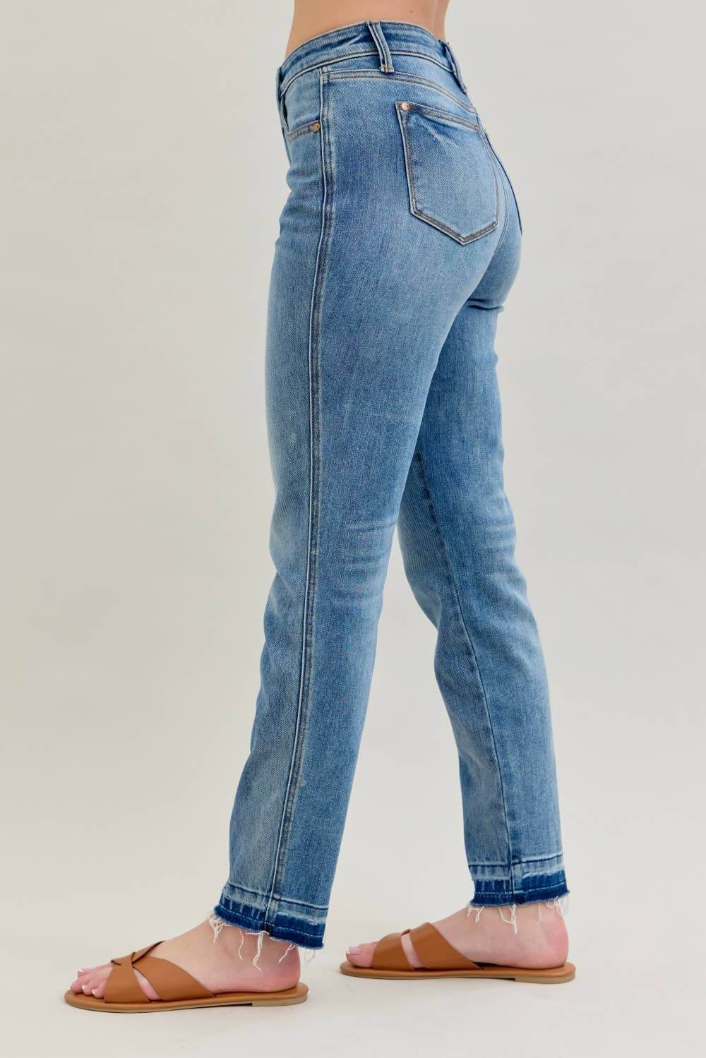 A model showcases the JUDY BLUE - AVERY JEANS, featuring a mid-rise fit and relaxed boyfriend cut with a stylish release hem.