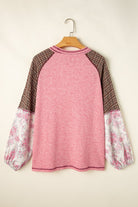 Mixed Blessings top with pink ribbed fabric, patchwork bubble sleeves, and raglan design, blending floral and plaid prints.