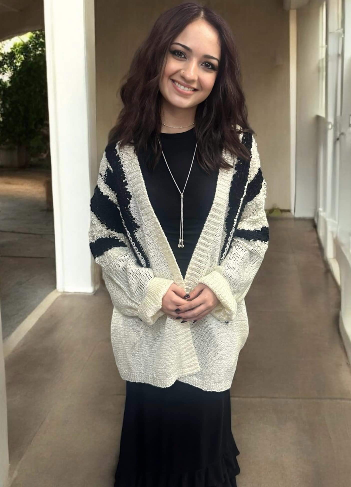 Woman wearing an ivory and black Ultra Soft Cardigan with a fuzzy texture and convenient pockets.