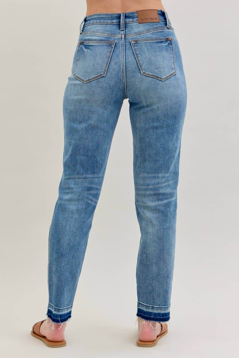 Back view of JUDY BLUE - AVERY JEANS showcasing the mid-rise fit and modern release hem detail.