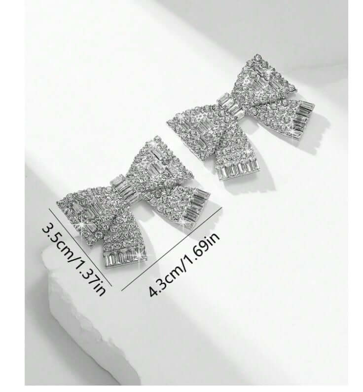 Sparkling Bows Earrings featuring shimmering rhinestones on silver tone, measuring 1.37" x 1.69". Ideal for glamorous occasions.