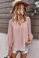 Stylish woman in Solid V Neck Lantern Sleeve Swiss Dot Shirt, perfect for casual outings and summer vacations.