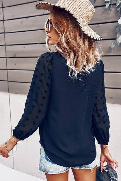 Back view of a woman wearing a navy Chateau Charm Top with Swiss dot sleeves and a straw hat.