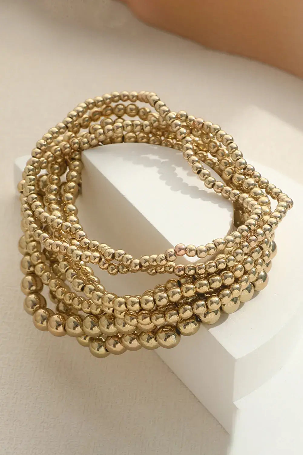 TIME TO SHINE Bracelet Set - Gold tone minimalist beaded bracelets stacked on a white display.