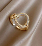 Gold tone cocktail ring with sparkling Cubic Zirconia circle on elegant fabric background. Adjustable size for a perfect fit.