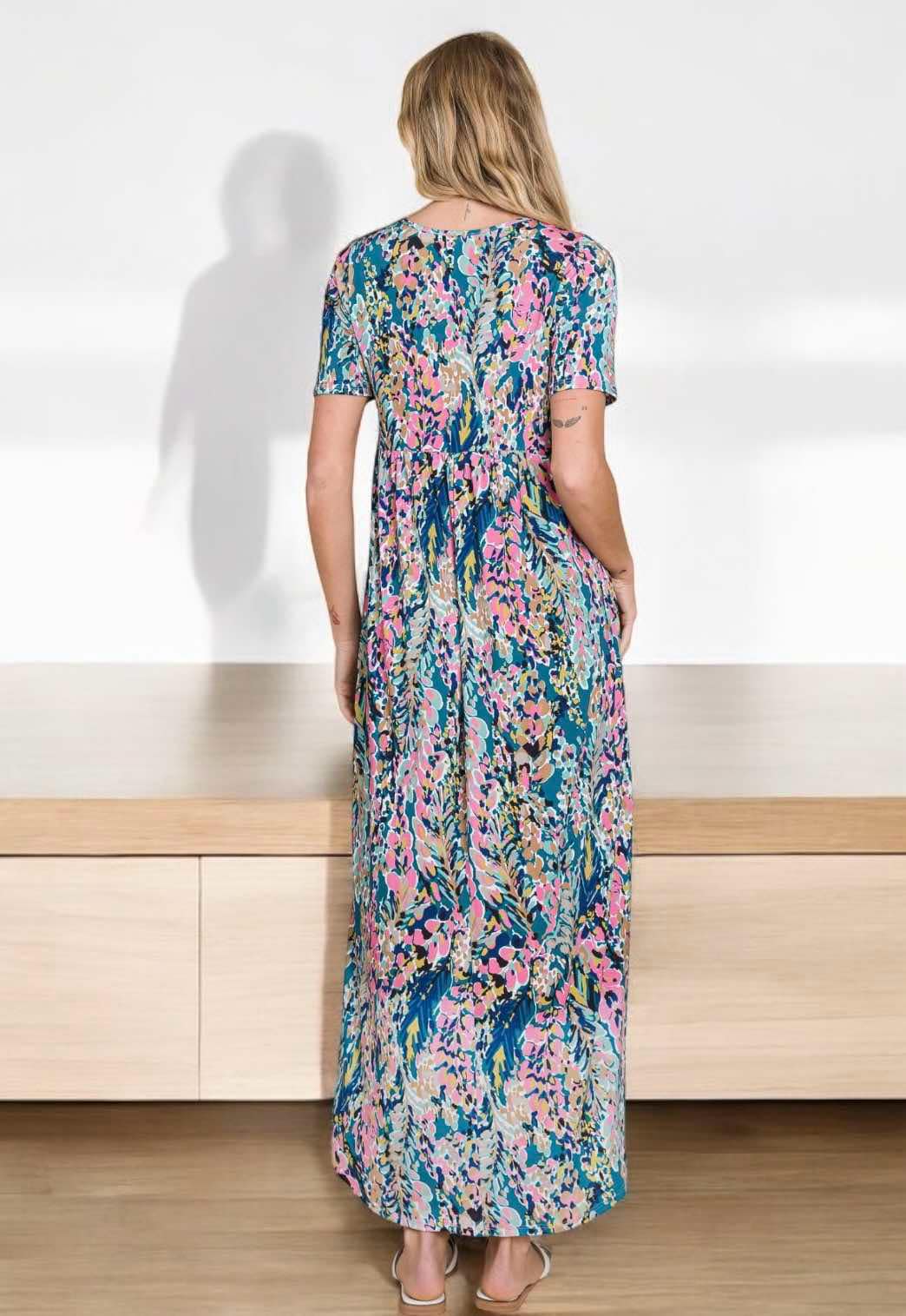 Back view of a vibrant abstract floral Watercolor Wonder maxi dress, perfect for summer wear.