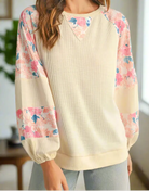 Lightweight vanilla top with floral patchwork, balloon sleeves, and elegant crew neck for a stylish look.