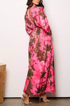 Model wearing a pink floral maxi dress with 3/4 sleeves and elastic waist from the back.