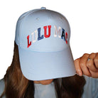 Model wearing a Red White and Lulu (Mac) Hat featuring vibrant red, white, and blue colors for a sporty look.