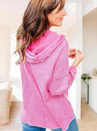 Woman wearing pink waffle-knit Henley hooded top with long sleeves, showcasing back view for casual style.