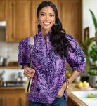 Model wearing the DreamLand Top in vibrant purple and navy, showcasing ruffled sleeves and a chic collar.