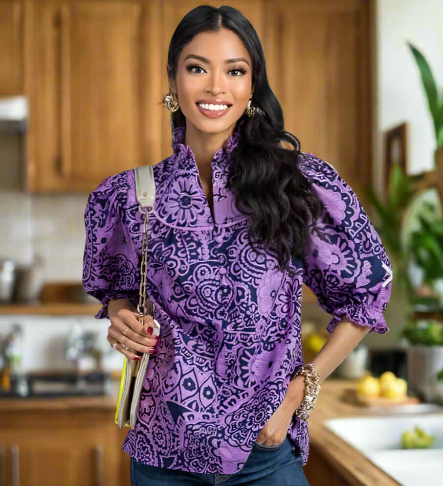 Model wearing the DreamLand Top in vibrant purple and navy, showcasing ruffled sleeves and a chic collar.