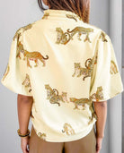 Woman wearing Vivian-Lu Cheetah Print Top with bubble sleeves and frilled collar, showcasing a chic and stylish design.