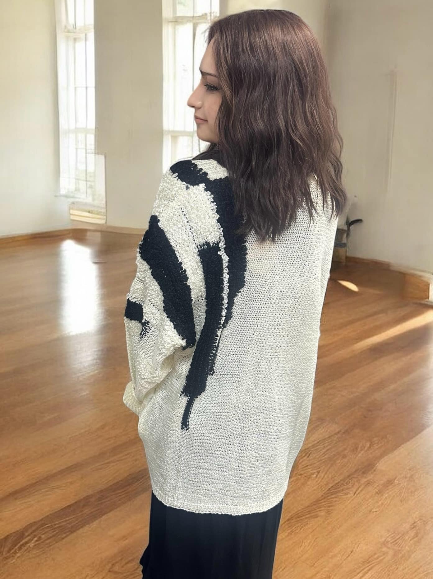 Woman wearing ivory and black ultra soft cardigan with fuzzy texture, showcasing its warm and stylish design.