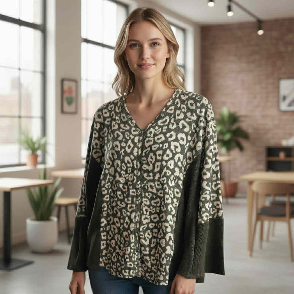 Model wearing UNTAMED SPIRIT TOP (Chai Latte) with leopard print in a cozy cafe setting.