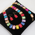 CANDY CONFETTI JEWELRY SET featuring colorful rhinestone crystals in a vibrant arrangement, displayed on a black velvet cushion.
