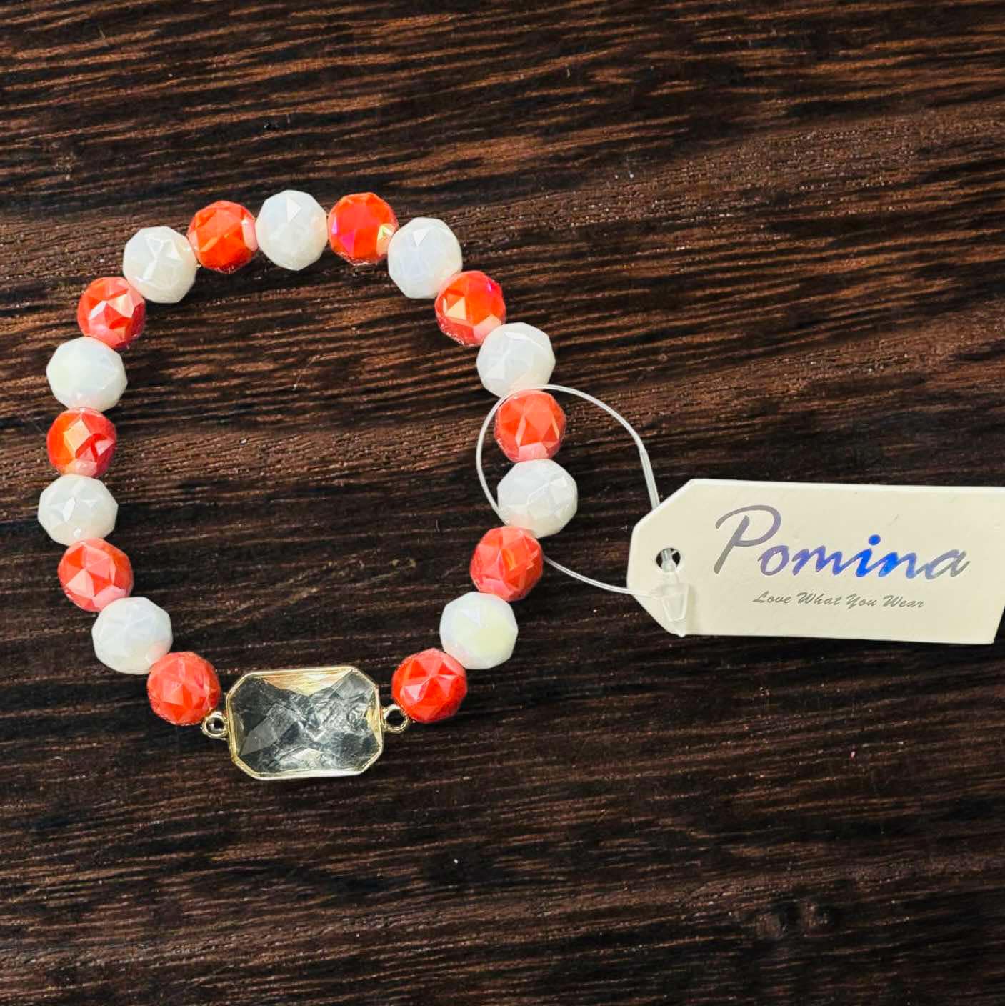 Pomina Level Up bracelet with coral and ivory beads featuring a rectangular glass gemstone and gold tone edge.